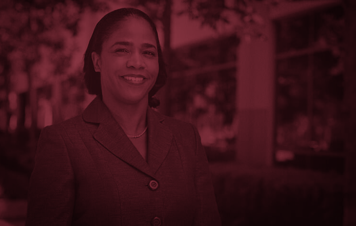 female_faculty_standing_outside_daytime_smiling