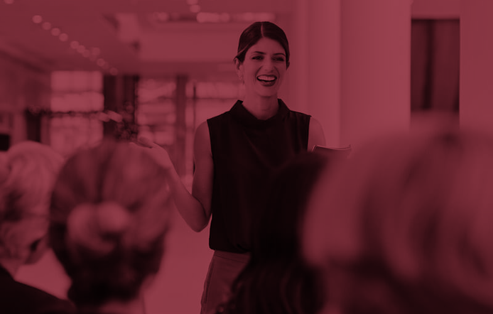 confident woman leader speaking to a group of coworkers