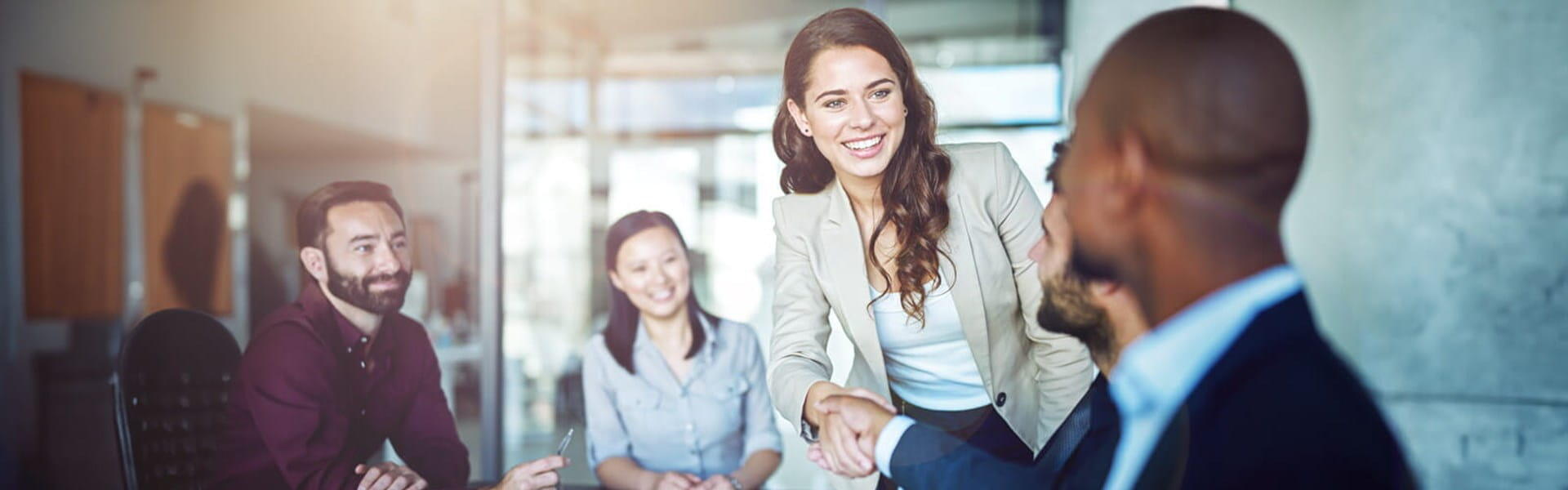 female in business suit shaking hands with a male colleague