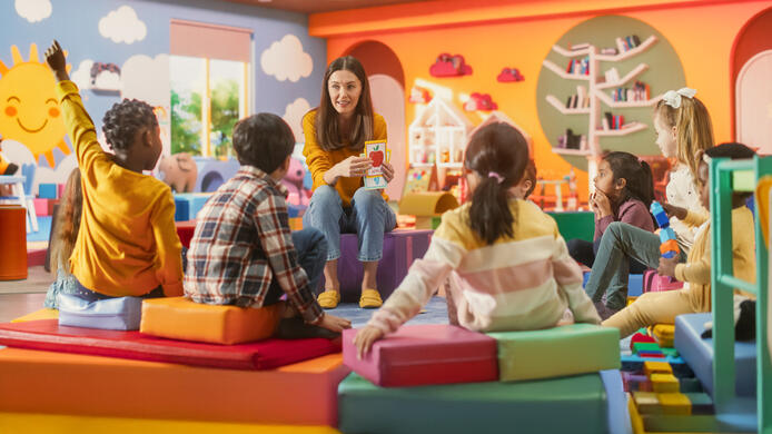 Cheerful Preschool Educator Playing and Creatively Studying with Multiethnic Kids in Kindergarten. Small Adorable Children Getting Basic Reading and Writing Skills, Learning Alphabet