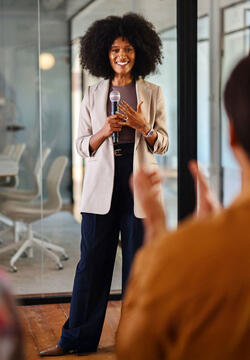 Black woman leading a panel discussion about sustainability in the office