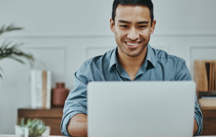 Student smiling and sitting with laptop.