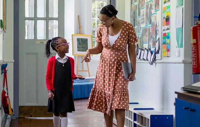a school counselor talking to a girl student while walking
